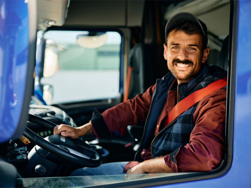 Truck driver in cab to illustrate driver shortages in hauling services
