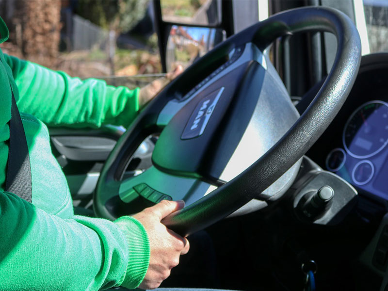 driver at the steering wheel of a truck to illustrate rising costs for trucking companies