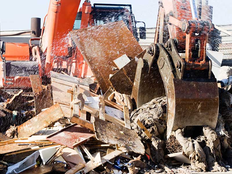 Grabber clearing debris to illustrate how trucking services enhance demolition services