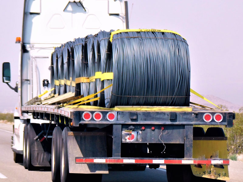 flatbed service truck carrying large bundles of wire