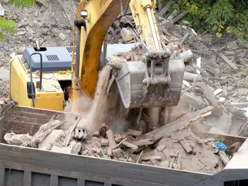 debris being loaded into dump truck to illustrate complete demolition services