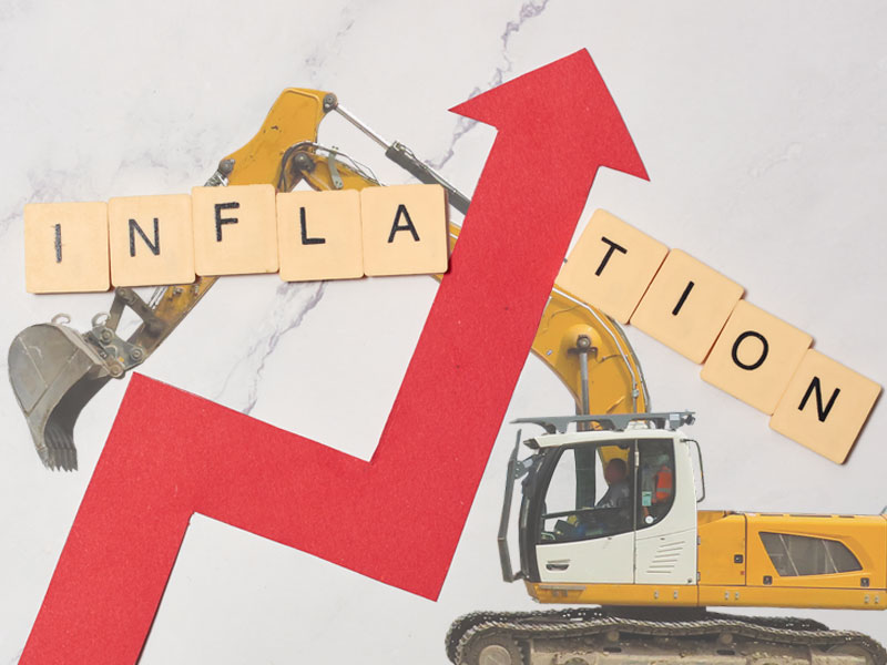 the word inflation and a red upwards arrow over a big digger to illustrate rising inflation for infrastructure contractors