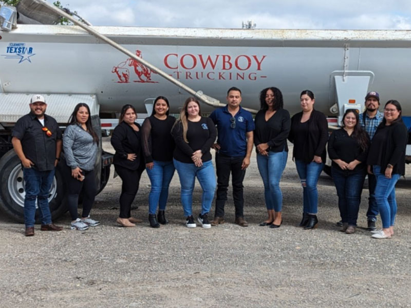 The team at Cowboy Truckinh in front of a truck to illustrate the interview about construction hauling with CEO Luis Diaz